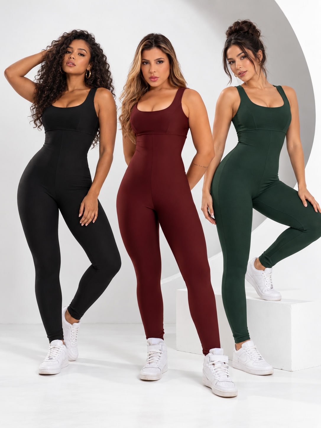 Três mulheres usando o macacão de compressão Atletiva Eixo nas cores preto, vinho e cinza
